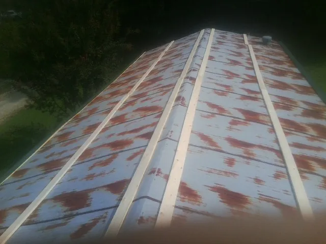 Rusted metal roof panels with new wood purlins before replacement — Storm Damage Roof Repair in Blue Jay by Roofing Brothers