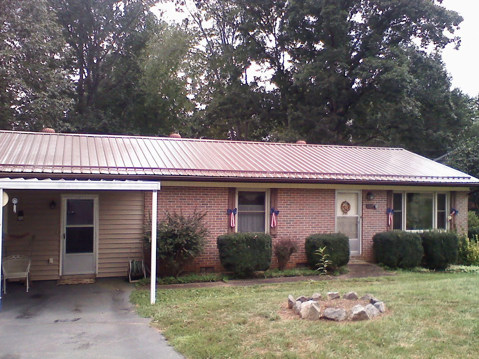 Bronze metal roof and carport on a brick ranch home — Roof Repair work by our crew in Blue Jay